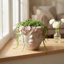 Artículo Maceta colgante con forma de cabeza de planta, aspecto hormigón, color rosa, altura 13 cm.