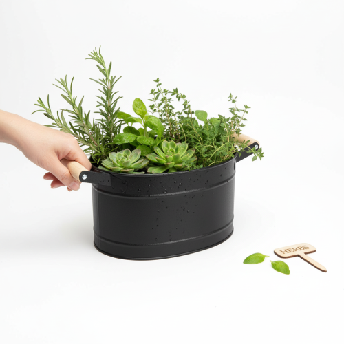 Artículo Maceta ovalada de metal con asa, acabado negro y natural, 34 x 19,5 x 15 cm.