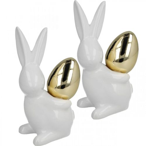 Artículo Conejos con huevo de oro, conejos de cerámica para Pascua blanco noble, dorado H13cm 2pcs