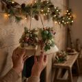 Decoración rústica de pared con campanas navideñas, ramas de abeto de yute y piñas. | Floristik24.es