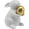 Floristik24 Conejo con huevo de oro de cerámica, decoración de Pascua blanco elegante, dorado Al. 15 cm